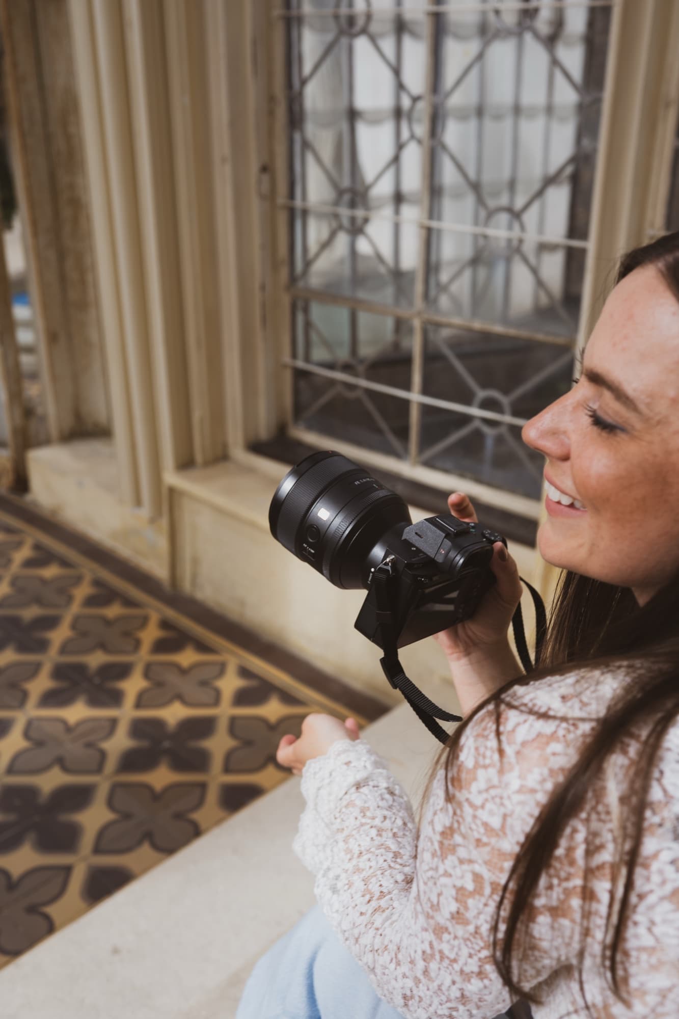 Petra Venušová s fotoaparátem u okna