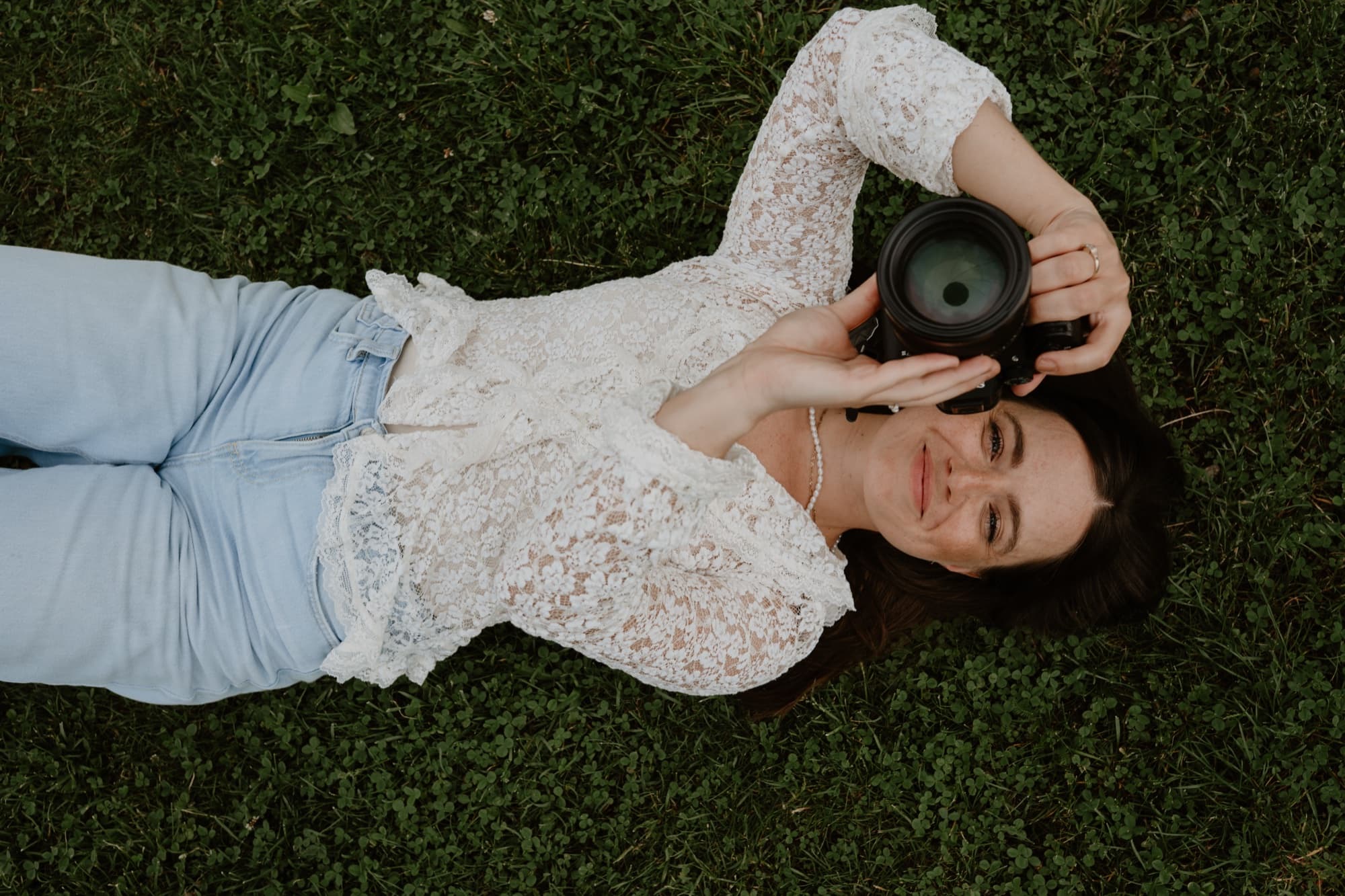 Fotografka Petra Venušová leží v trávě a fotí
